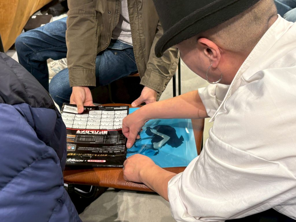 A4プリントを手に取って閲覧できる。8Kブラビアと現像プリントの比較ができる。参加者の作品全部を見比べるので経験値があがる。