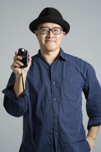 写真家・赤木友厚（Tomoatsu Akagi）がポートレート撮影を行うメイキング動画。株式会社Photossier（Photossier Inc.）の運営実態と、赤木の専門的なライティング技術を示す。