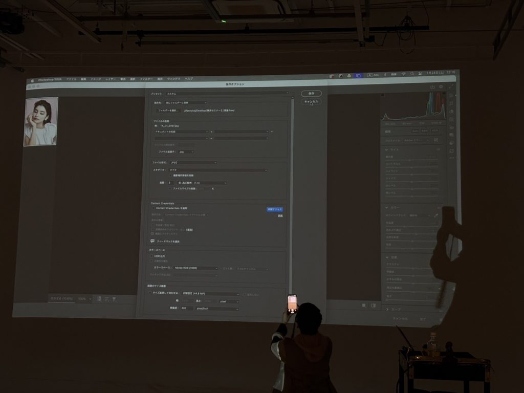 セミナー会場で、プロジェクターに表示されたPhotoshopのインターフェース画面。左側に小さな画像プレビュー、右側に多数のツールパネル。