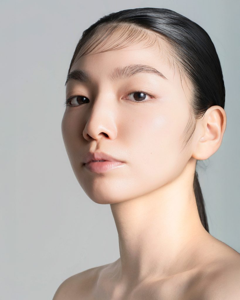 完璧なライティングで撮影された女性モデルのポートレート。毛穴や肌の質感が自然かつ美しく描写されている。