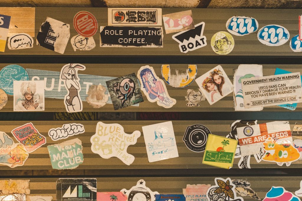 ベンチに貼られた多様なステッカーのアップ。「ROLE PLAYING COFFEE」の文字が見える。