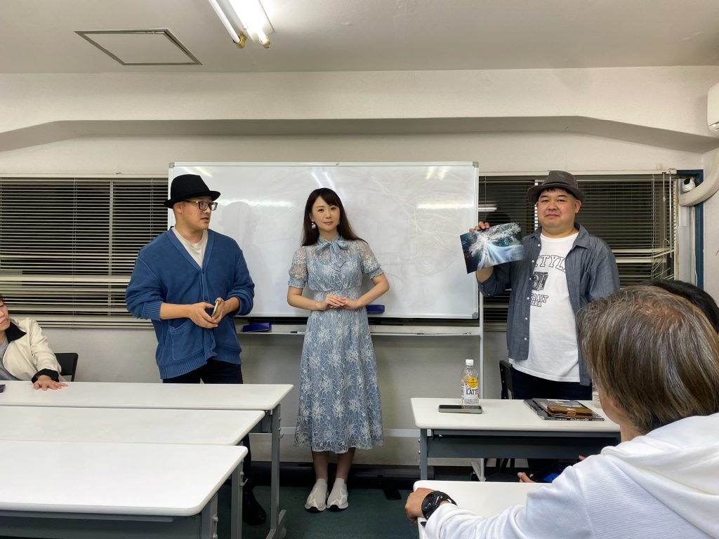 ホルン会議室の全体。ホワイトボードの前に立ち、作品について議論するフォトグラファーたちの様子