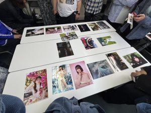 会議室の机の上に、様々なポートレート写真のA4プリントが並べられている様子