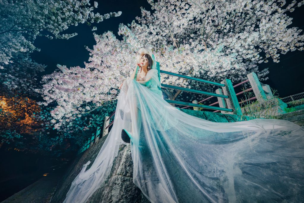 夜の満開の桜の下で、白いドレスを纏ったモデルの宮崎舞子さんが佇む幻想的なポートレート