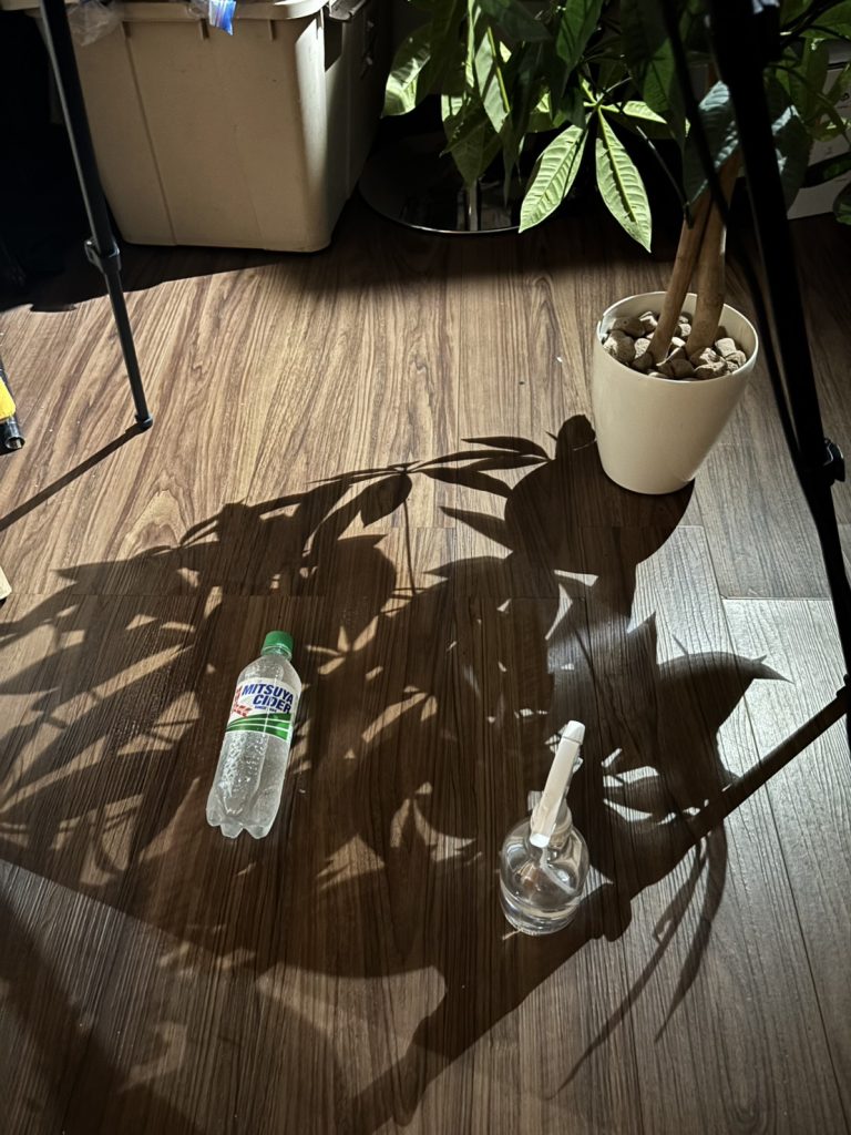 ASUS ProArtモニターの前に被写体の男性を配置し、ブームアームに取り付けたストロボで上部からライティングする撮影風景。