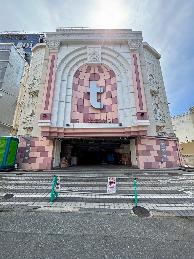 解体工事が始まり、足場で囲まれたタバサホテルラテンの外観写真。かつてのネオン看板が撤去され、建物の取り壊しが進んでいる様子